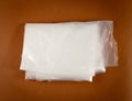 Folded White Plastic Bags on Brown Background, Crumpled Plastic Bag after Shopping, Cellophane Packaging Waste