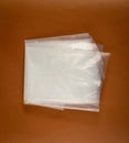 Folded White Plastic Bags on Brown Background, Crumpled Plastic Bag after Shopping, Cellophane Packaging Waste