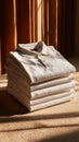 Folded white polo shirt stack on carpet with warm sunlight and brown curtain background Royalty Free Stock Photo
