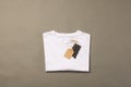 Folded white t shirt with tags with copy space on brown background Royalty Free Stock Photo