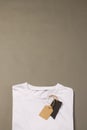 Folded white t shirt with tags with copy space on brown background Royalty Free Stock Photo