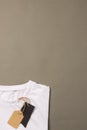 Folded white t shirt with tags with copy space on brown background Royalty Free Stock Photo