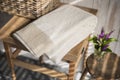 Folded White Towel with Brown Herringbone Design on Square Sidetable