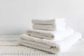 Folded white towels of different sizes on a white wooden table. Spa and wellness, cotton terry textile. Ecological theme Royalty Free Stock Photo