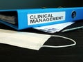 Folder with label clinical management and medical mask