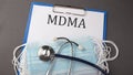 Folder with paper text MDMA , on a table with a stethoscope and medical masks, medical concept