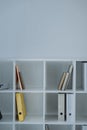 folders and books on white shelves