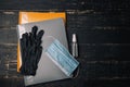 Folders for documents, medical gloves, gauze mask and sanitizer for disinfection on black wooden background.