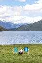 Folding beach chairs facing a lake