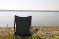 A folding camp chair stands on the Bank of the river Royalty Free Stock Photo