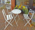 folding chairs and round table outdoor seating, brick sidewalk in Fall at restaurant