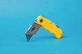 Folding knife for cutting paper and cardboard on a blue background Royalty Free Stock Photo