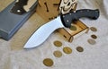 Folding knife stainless steel sharp blade black handle money gray background