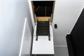 Folding metal stairs to the attic in the ceiling, open hatch and complex stairs, modern look.