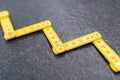 Folding zig zag ruler. Measuring tape folding yellow open in zigzag tips on a workbench. Measuring tools for carpenters and Royalty Free Stock Photo