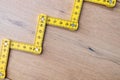 Folding zig zag ruler. Measuring tape folding yellow open in zigzag tips on a workbench. Measuring tools for carpenters and Royalty Free Stock Photo