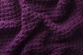 Folds of knitted fabric as a background.Top view of dark purple knitting texture