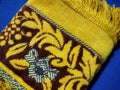 folds of a yellow moslem prayer rug on a blue background
