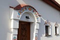 Folk architecture, decoration of the entrance to the wine cellar. White facade with painted flowers.
