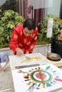 Folk artist in red tang suit make traditional chinese sugar painting