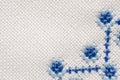 Folk embroidered fragment on cloth by cotton threads. Macro texture cross-stitch. Royalty Free Stock Photo