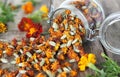 Folk medicine. Dried red flowers of marigold-marigolds on a wooden background in a glass jar for storage.The benefits of medicinal Royalty Free Stock Photo