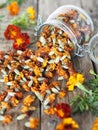 Folk medicine. Dried red flowers of marigold-marigolds on a wooden background in a glass jar for storage.The benefits of medicinal Royalty Free Stock Photo