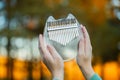 Folk music instrument. Hands holding kalimba. Meditative hobby. Beautiful transparent thumb piano