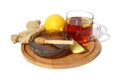 Folk remedies for colds. There is a plate with honey, tea, lemon and ginger on a wooden round board.