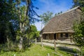 Folk scenic view Eastern European rural wooden village house cabin in garden park trees surrounding in summer colorful clear