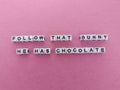 Follow that bunny he has chocolate Easter message on a pink background Royalty Free Stock Photo