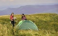 Follow instructions. Group friends set up tent on top mountain. Teamwork concept. Hiking activity. Helpful have partner