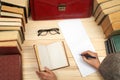 Follow the law. Professional lawyer sitting at the table and signing papers. On a wooden table books, documents, glasses, red brie Royalty Free Stock Photo