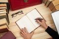 Follow the law. Professional lawyer sitting at the table and signing papers. On a wooden table books, documents, glasses, red brie Royalty Free Stock Photo