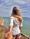 Follow me. Blonde girl standing back on the edge cliff Royalty Free Stock Photo