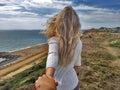 Follow me. Blonde girl standing back on the edge cliff Royalty Free Stock Photo