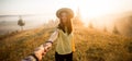 Follow me concept. Couple in love holding hands. Woman in yellow shirt and straw hat holding man by hand going to autumn Royalty Free Stock Photo