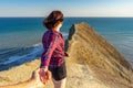 Follow me. Hand in hand. Teen tourist girl standing on mountain cliff against beautiful landscape of sea, cape and sky in sunny Royalty Free Stock Photo