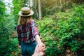 Follow me photo in the mountains. Stylish woman in checkered shirt and straw hat. Wanderlust concept. Couple hiking and travelling