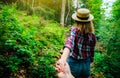 Follow me photo in the mountains. Stylish woman in checkered shirt and straw hat. Wanderlust concept. Couple hiking and travelling Royalty Free Stock Photo