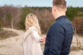 Follow me. Romantic concept. Young caucasian woman with long blonde hair outdoors holding guy`s hand.Traveling together