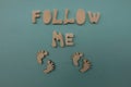 Follow me text composed with handmade wooden letters and feet