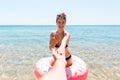 Follow me Vacation concept. woman calls to swim in the sea and waves her hand. Girl relaxing on inflatable ring in the sea. Summer