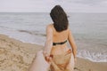 Follow me. Woman leading her man, holding hands on beach. Couple in love on summer vacation or honeymoon. Young woman with sandy