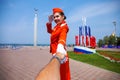 Follow Me, Young stewardess dressed in official red uniform of Airlines, Summer park outdoors