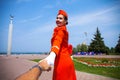 Follow Me, Young stewardess dressed in official red uniform of Airlines, Summer park outdoors