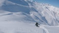 FOLLOW: Snowboarder girl rides off piste towards the slopes of a ski resort.
