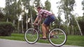 Follow to young handsome man riding a vintage bicycle outdoor. Sporty guy cycling at the park. Healthy active lifestyle Royalty Free Stock Photo