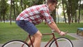 Follow to young handsome man riding a vintage bicycle outdoor. Sporty guy cycling at the park. Healthy active lifestyle Royalty Free Stock Photo