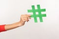 Follow trend, join popular blog! Closeup of female hand holding green hashtag sign, sharing tagged message